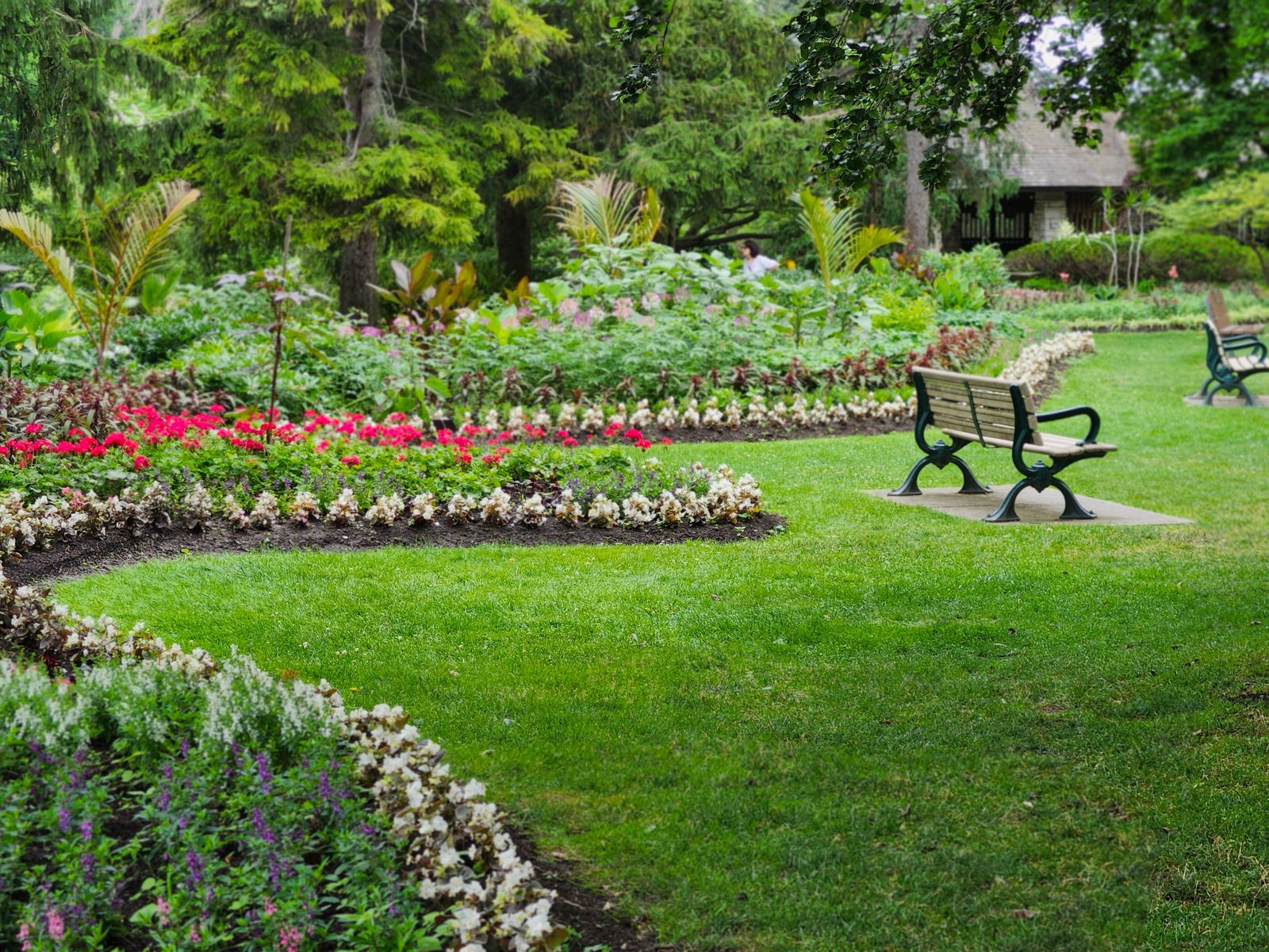 Parque con macizos de flores de bordes definidos y bancas